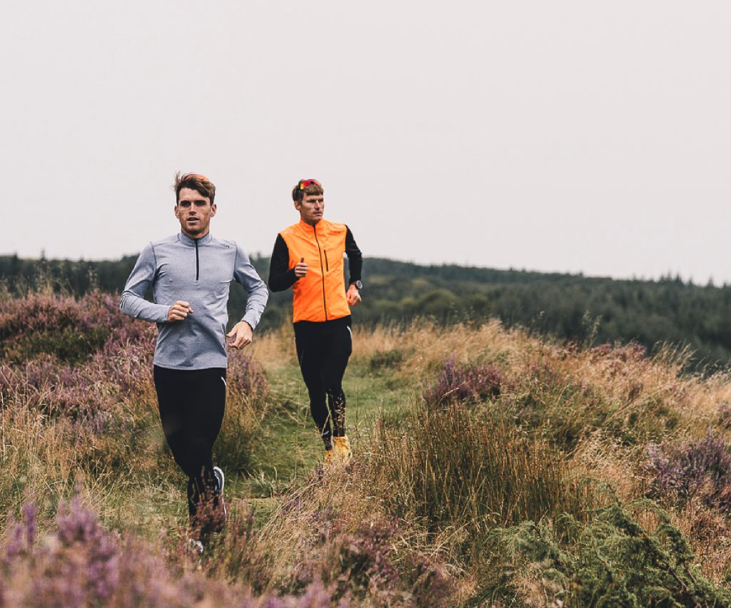 Two runners on a heathland trail in FUSION tops