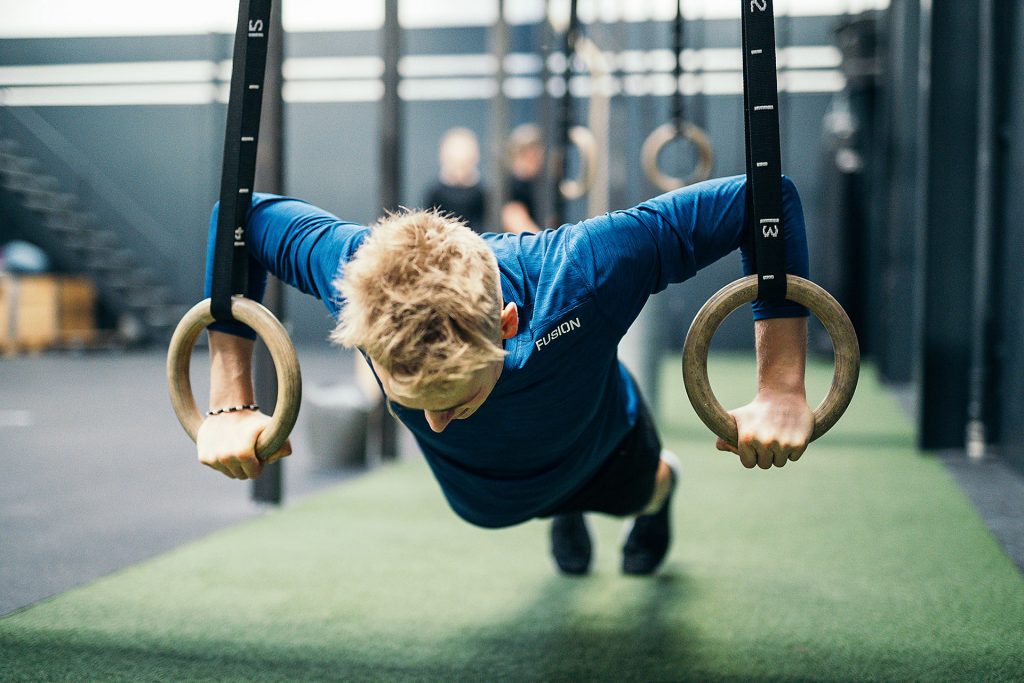 Athlete training on gymnastic rings in a FUSION top